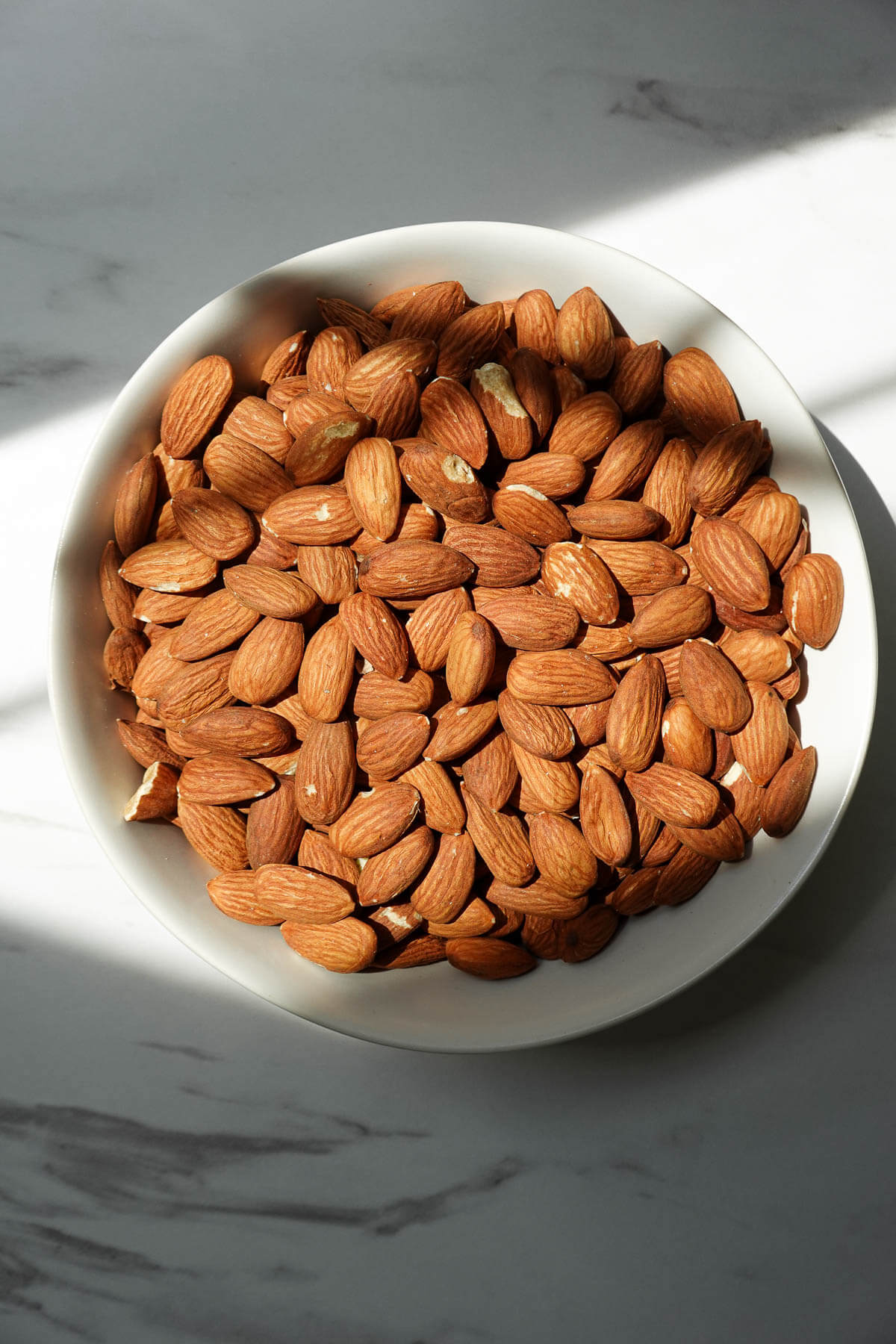 Whole raw almonds in a bowl.