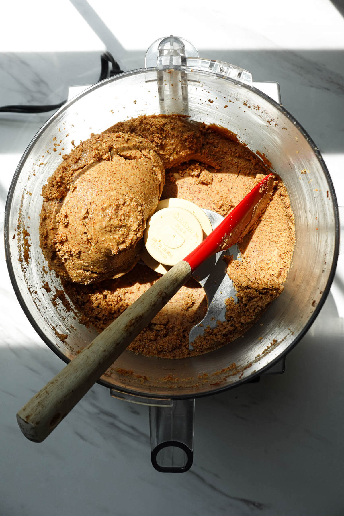 Almond butter in the thick, clumpy stage before becoming smooth.
