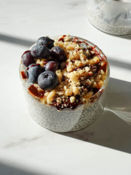 creamy chia pudding recipe in a glass jar topped with blueberries and chopped walnuts for a healthy breakfast