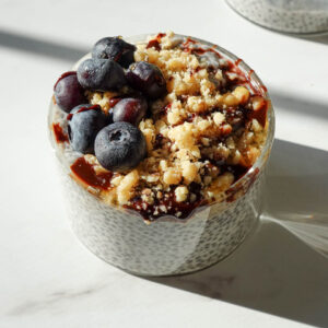 creamy chia pudding recipe in a glass jar topped with blueberries and chopped walnuts for a healthy breakfast