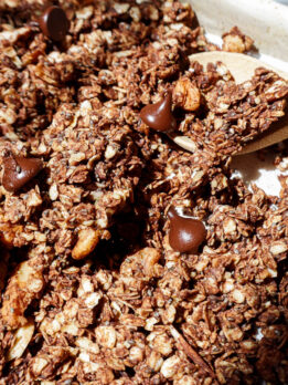 Crunchy homemade chocolate granola with oats and nuts on a baking sheet