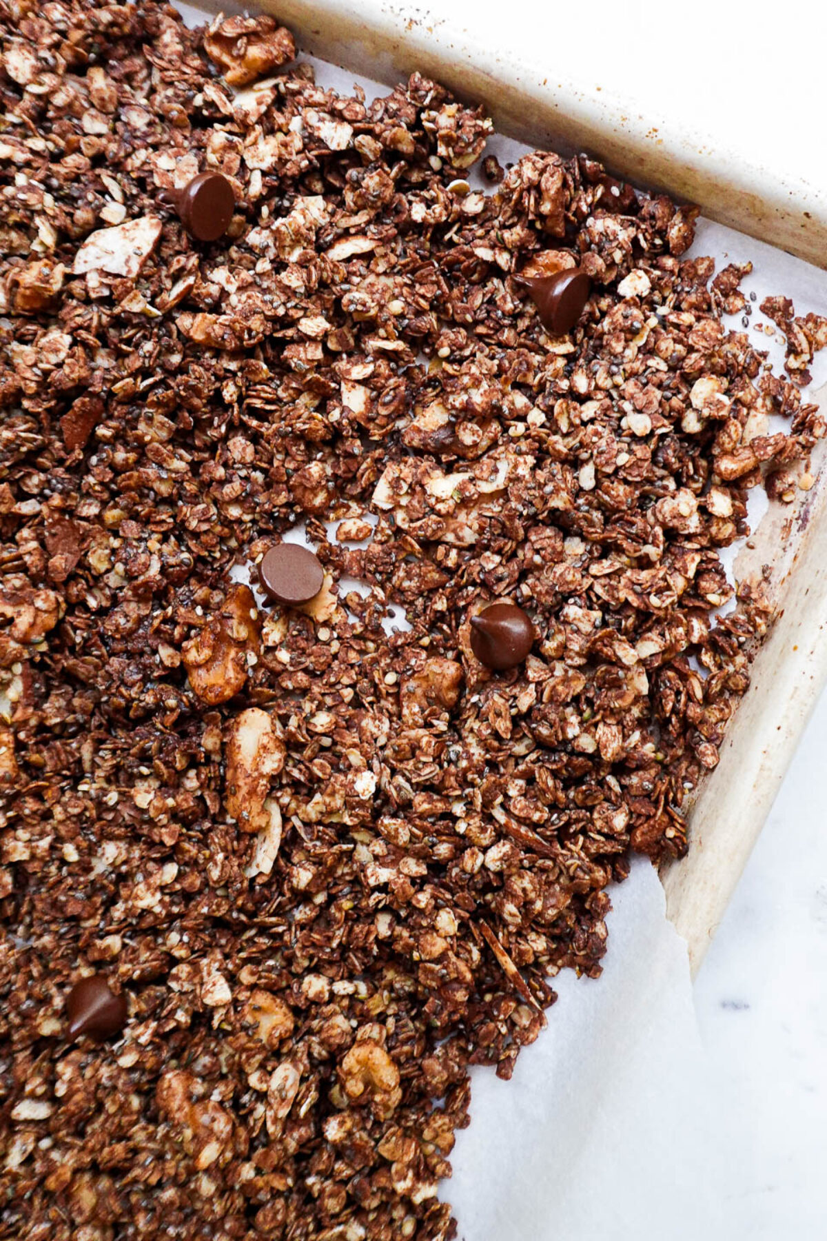 Crunchy healthy chocolate granola with oats and nuts on a baking sheet