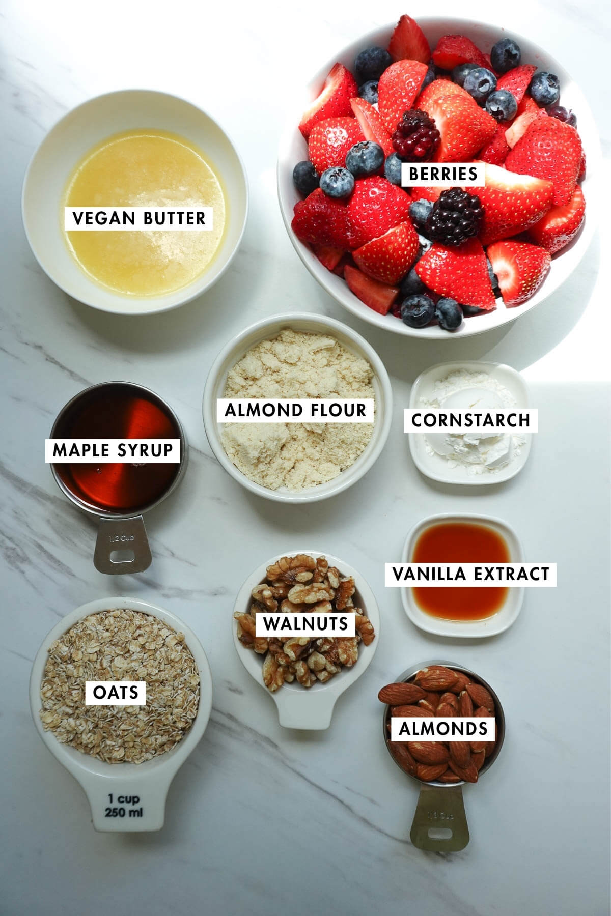 Ingredients needed to make healthy berry crisp arranged on a table.