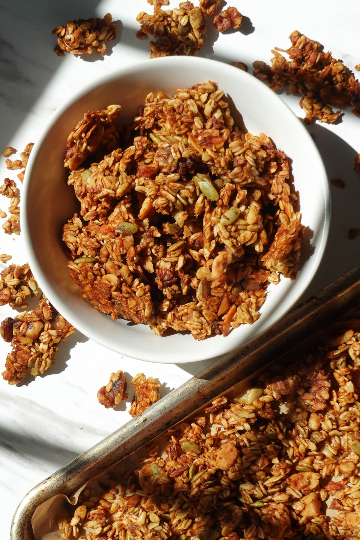 Vegan pumpkin spice granola with crunchy clusters, oats, nuts, and pumpkin seeds.