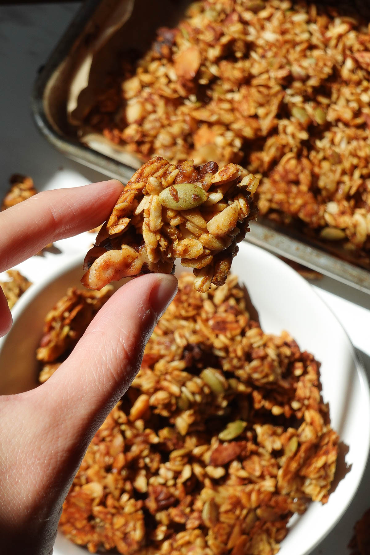 Holding a crunchy cluster of homemade pumpkin granola.
