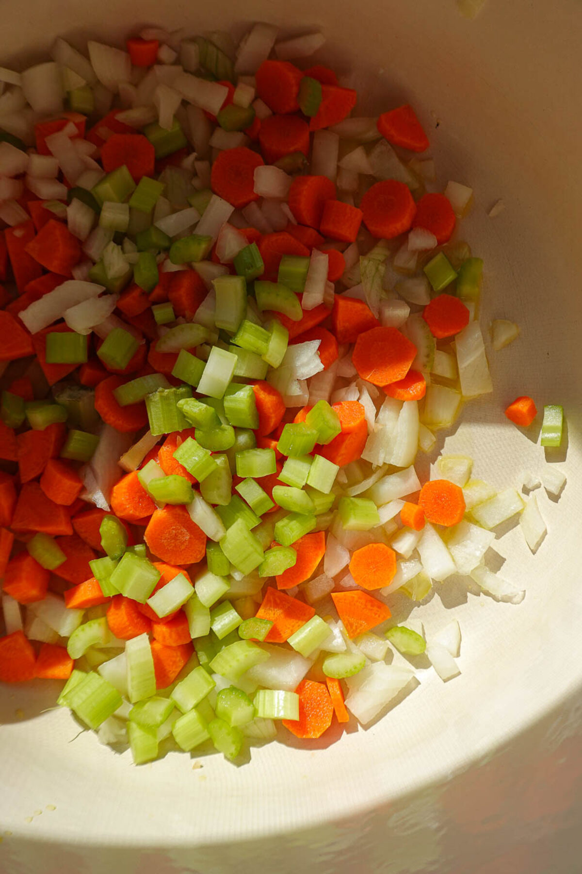 Sautéing onion, celery, and carrots in a pot to make butternut squash soup