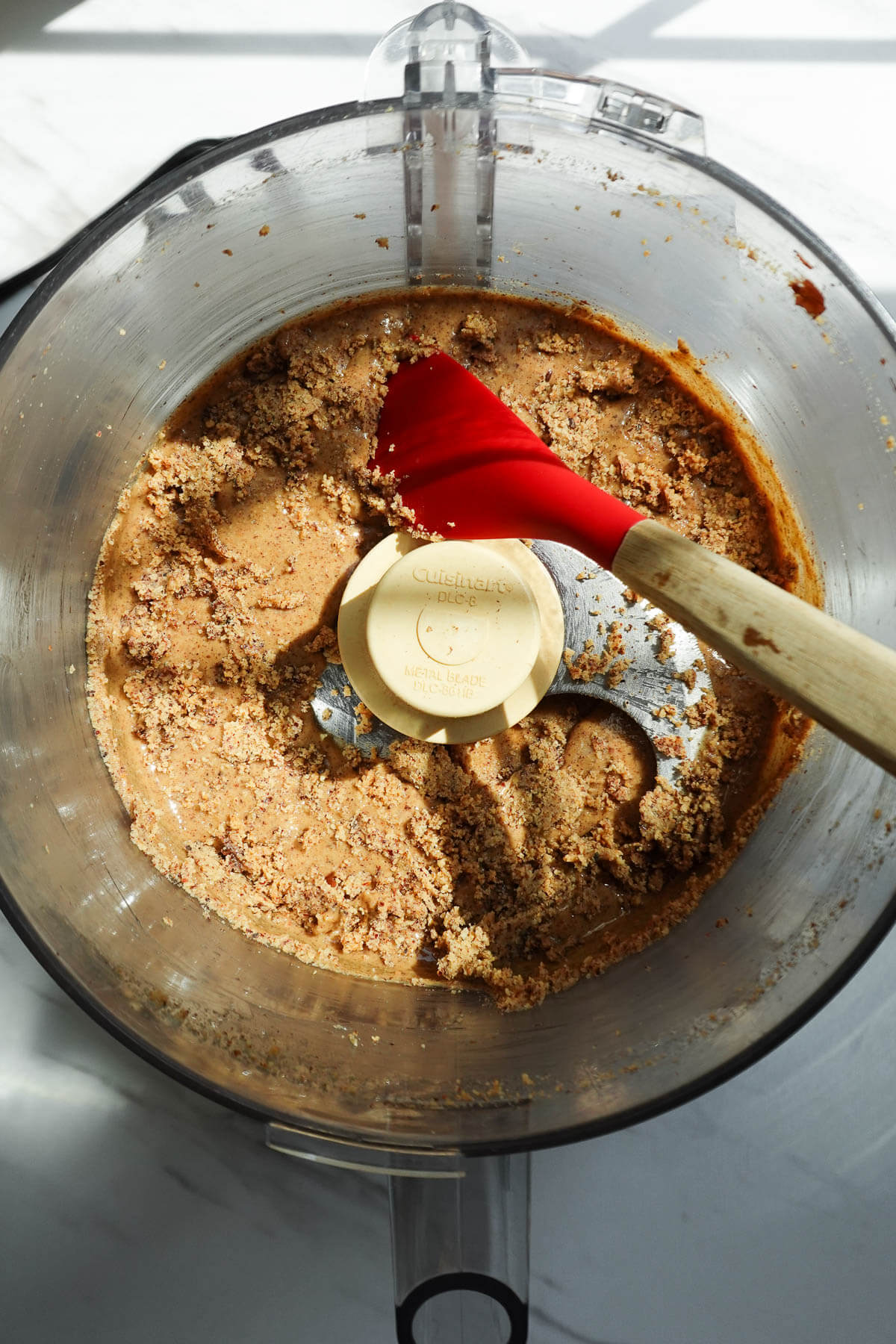 Hazelnuts in the crumbly stage while blending to make homemade hazelnut butter.