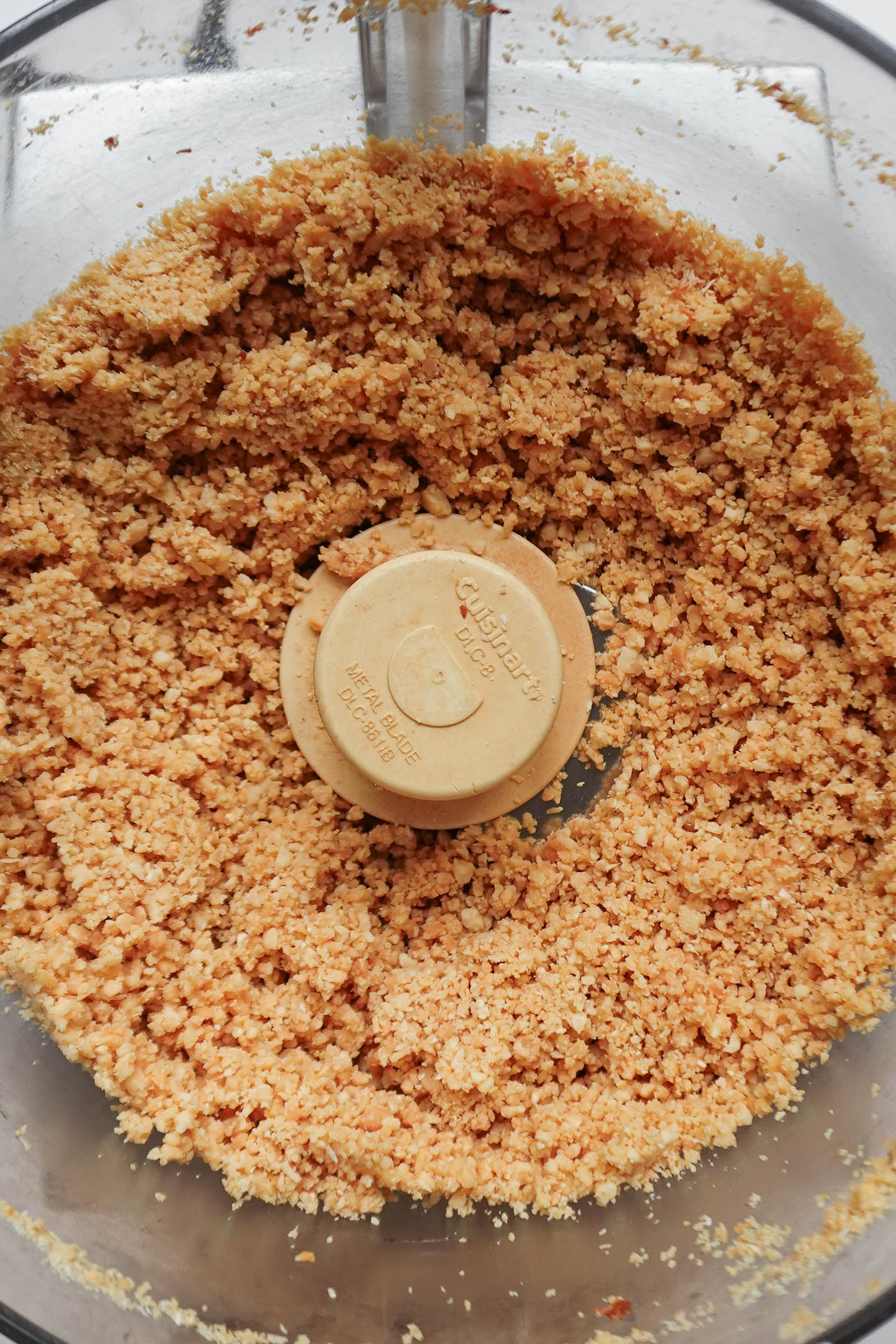 crumbly peanuts turning into creamy homemade peanut butter in food processor