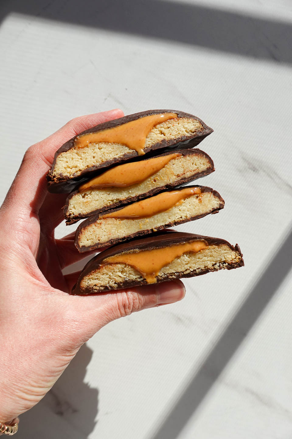 stack of homemade vegan and gluten-free Tagalongs with creamy peanut butter oozing out