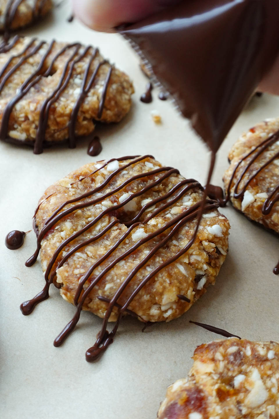 drizzling samoas cookies with melted chocolate