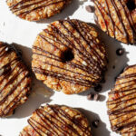 A plate of vegan samoas cookies with a dark chocolate drizzle