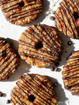 A plate of vegan samoas cookies with a dark chocolate drizzle