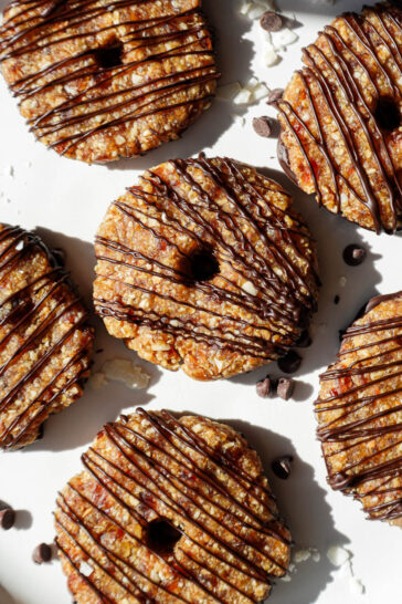 A plate of vegan samoas cookies with a dark chocolate drizzle