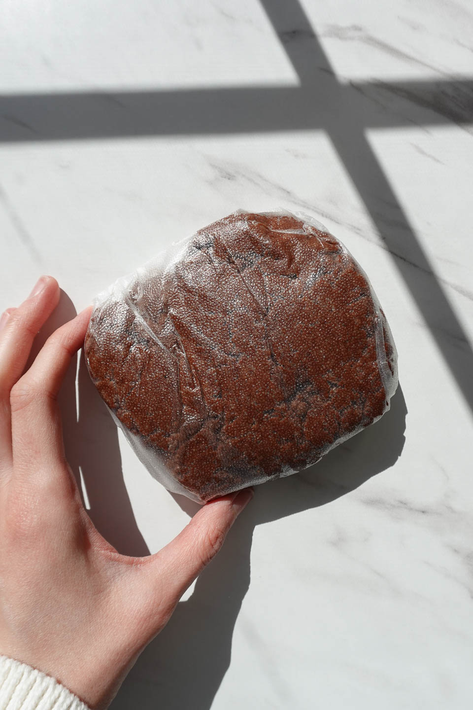 homemade thin mint dough wrapped in plastic wrap prior to freezing