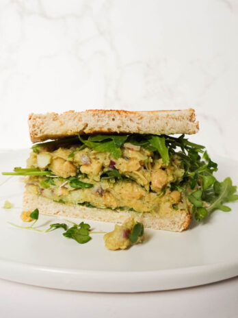 Vegan Chickpea Salad Sandwich with creamy chickpea filling, avocado, and lettuce on sourdough bread.