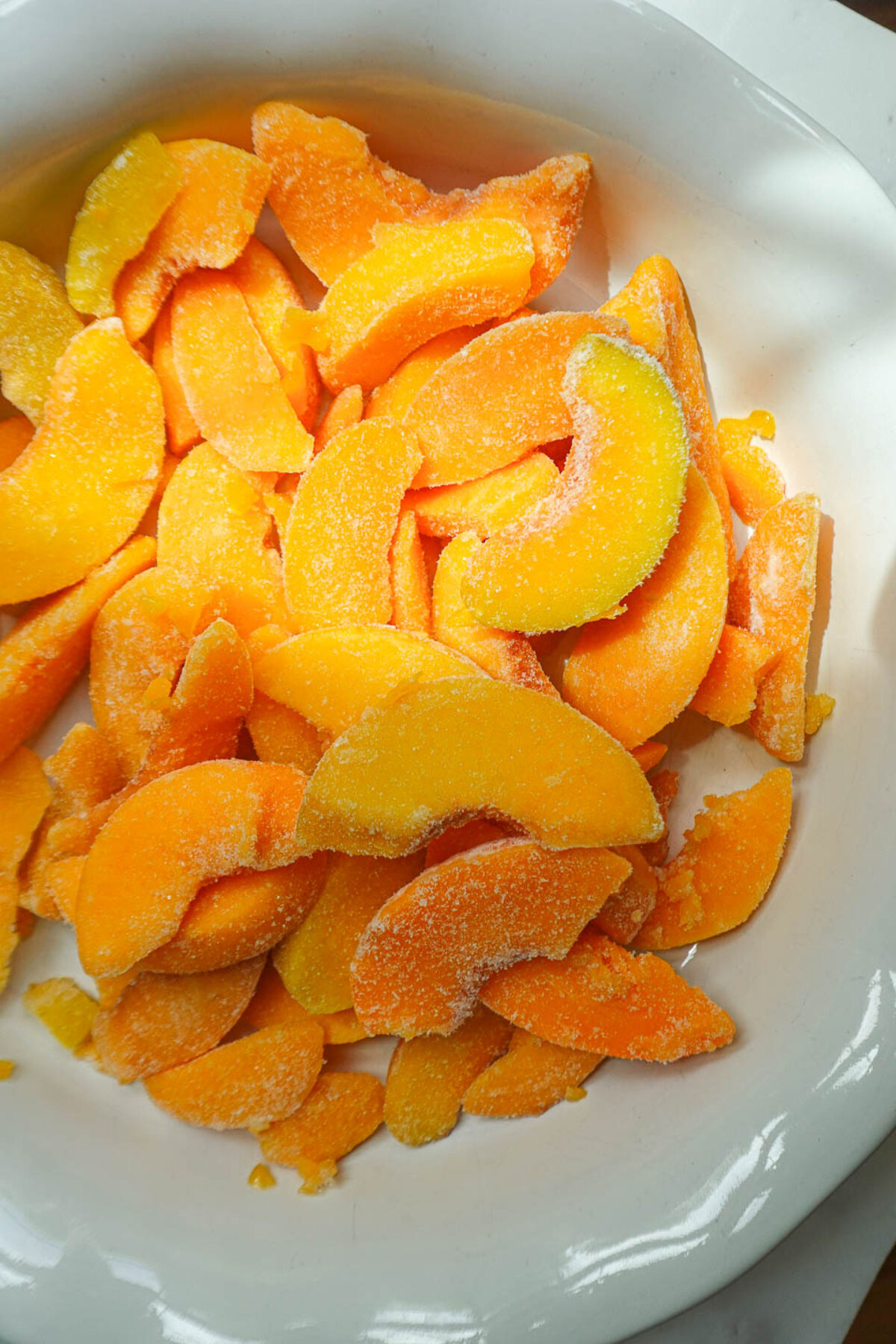 Sliced fresh peaches in a bowl, ready for peach crisp filling.