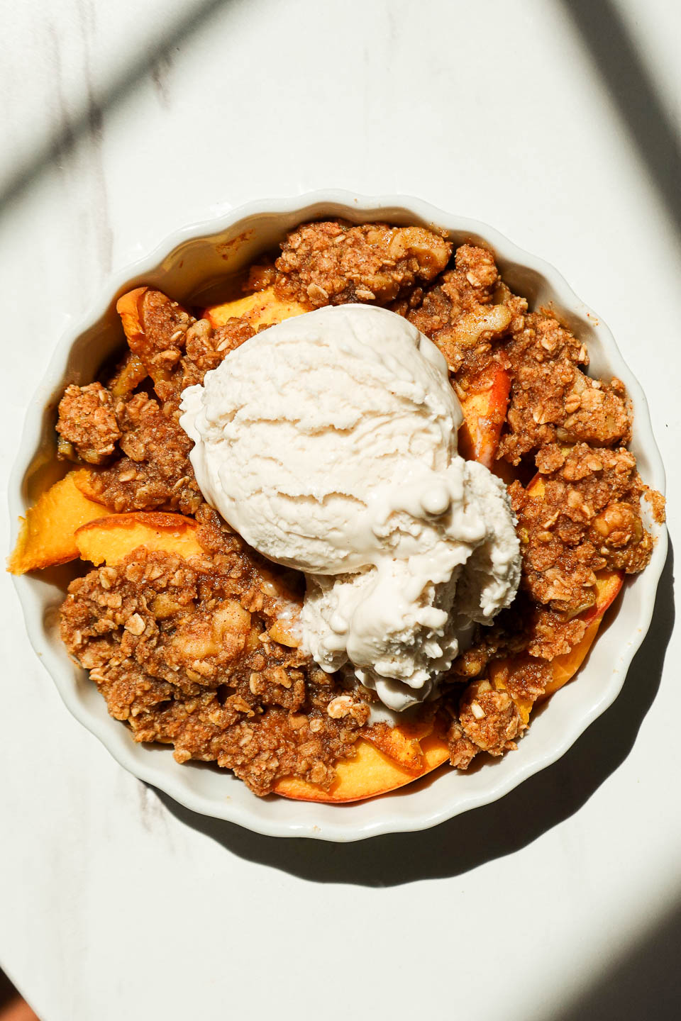 Single serve peach crisp with vegan vanilla ice cream and crunchy granola