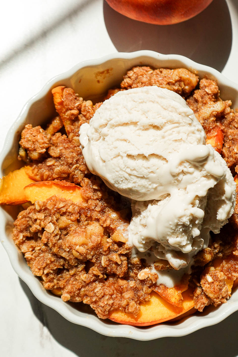 Healthy single serve peach crisp with juicy baked peaches and nutty crisp topping