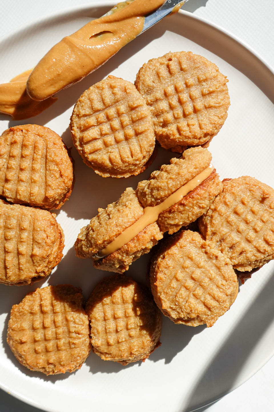 vegan and gluten-free homemade nutter butter cookies on a plate showing peanut butter filling