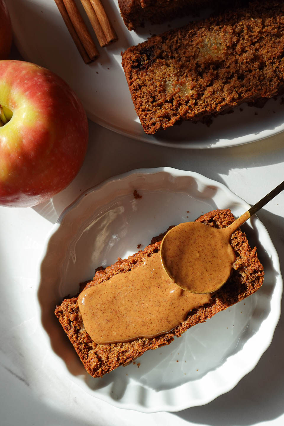 Slice of vegan apple bread served with almond butter on a plate