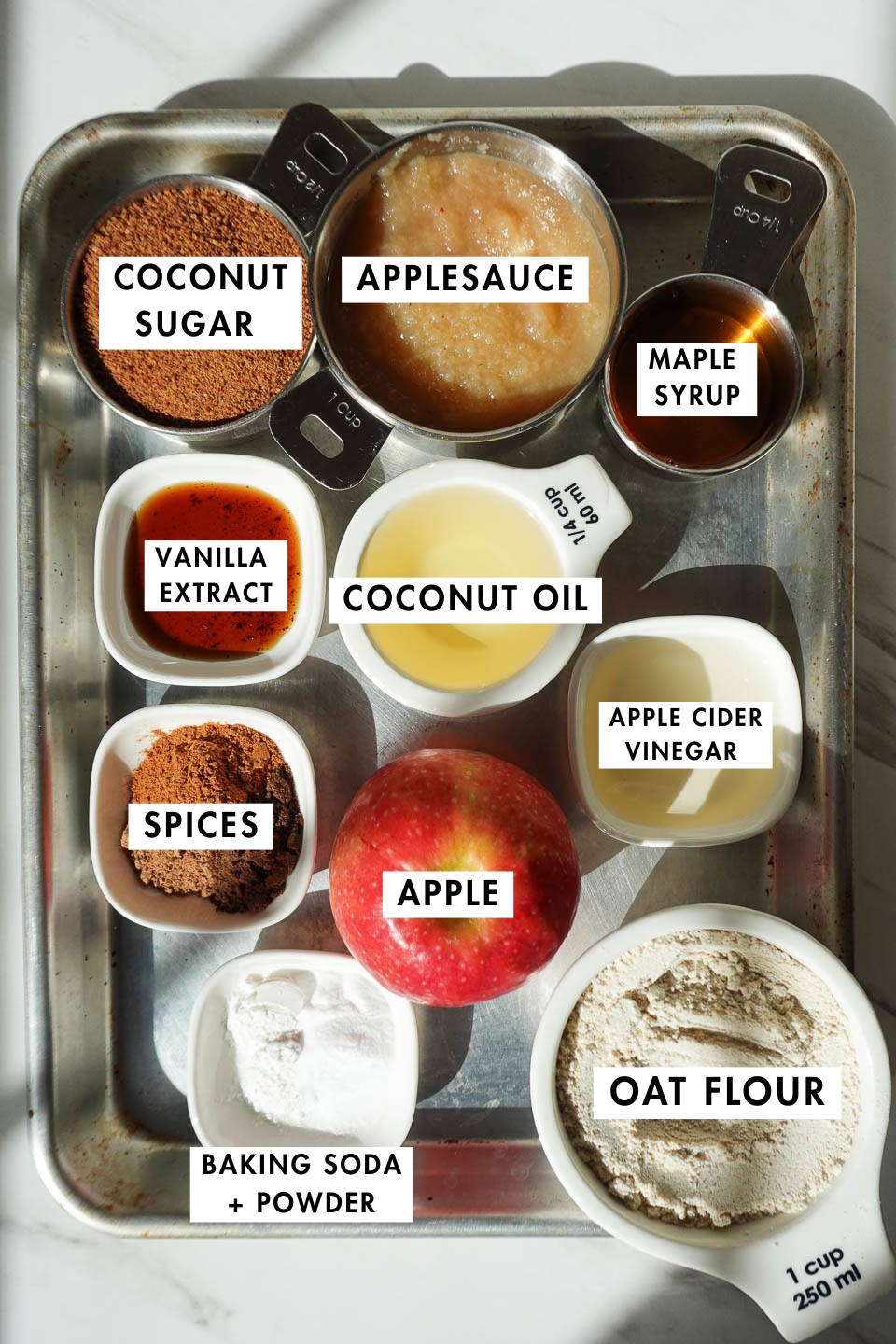Ingredients for healthy apple bread including oat flour, apples, maple syrup, and spices