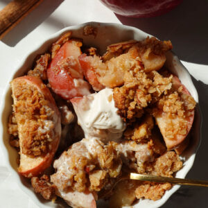 healthy apple crisp served in a bowl with vanilla ice cream