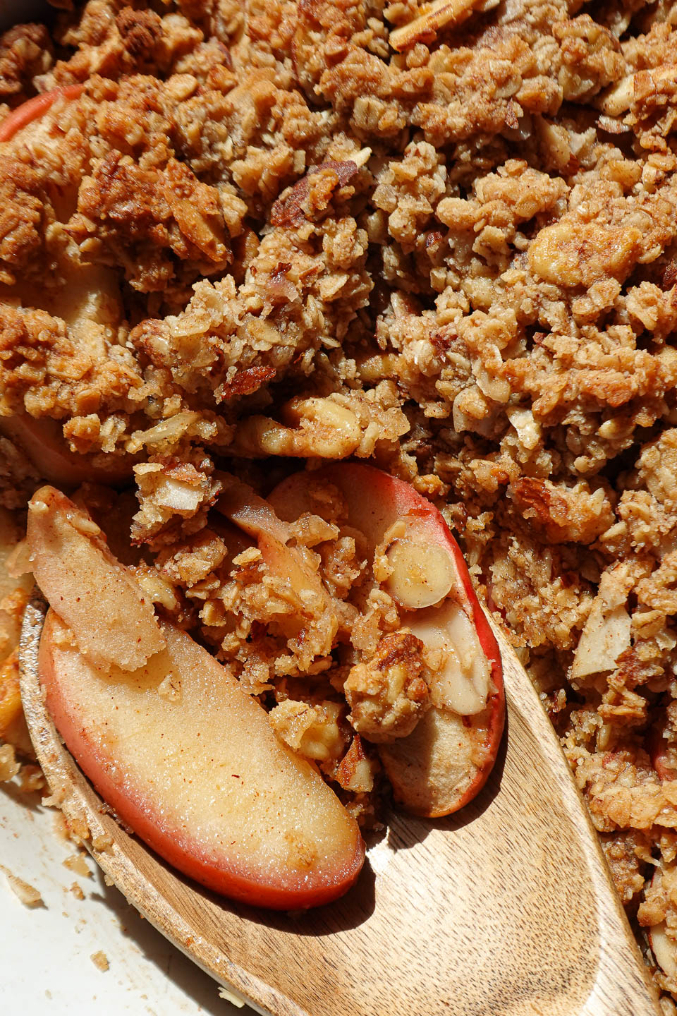 close up of spoon with apple crisp baked golden brown