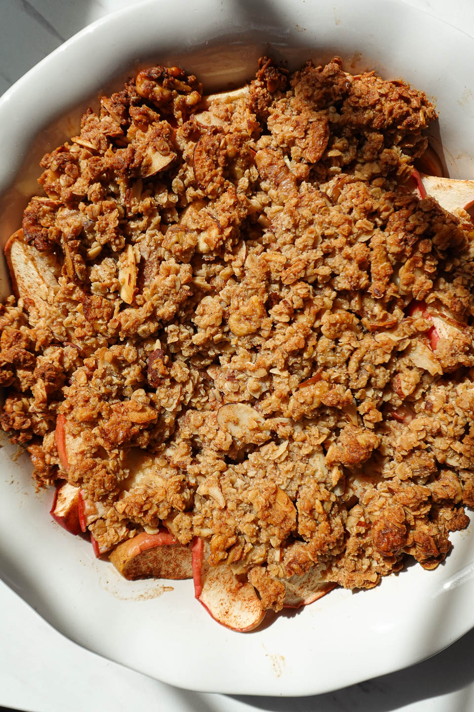 Healthy apple crisp baked golden brown in a white baking dish
