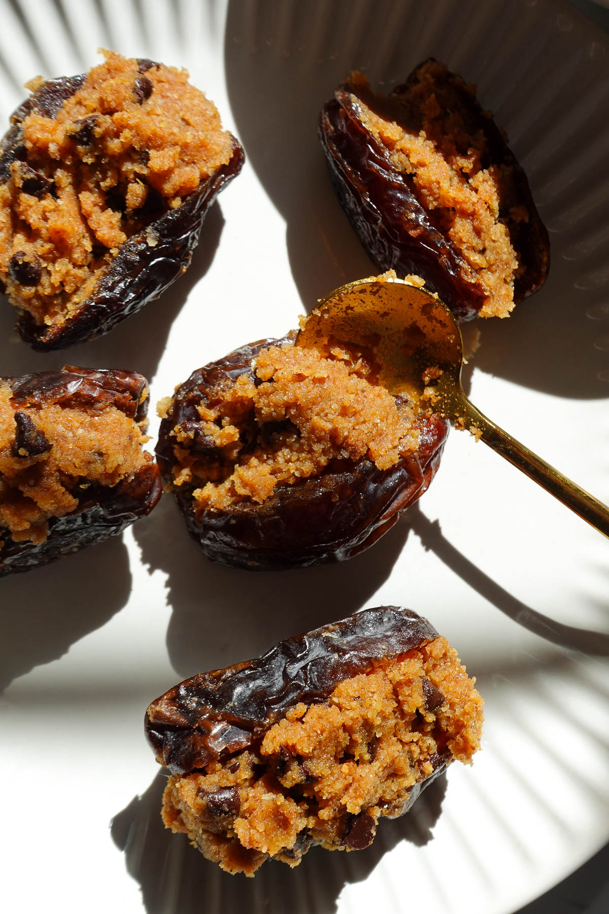 Adding pumpkin cookie dough to a pitted medjool date.