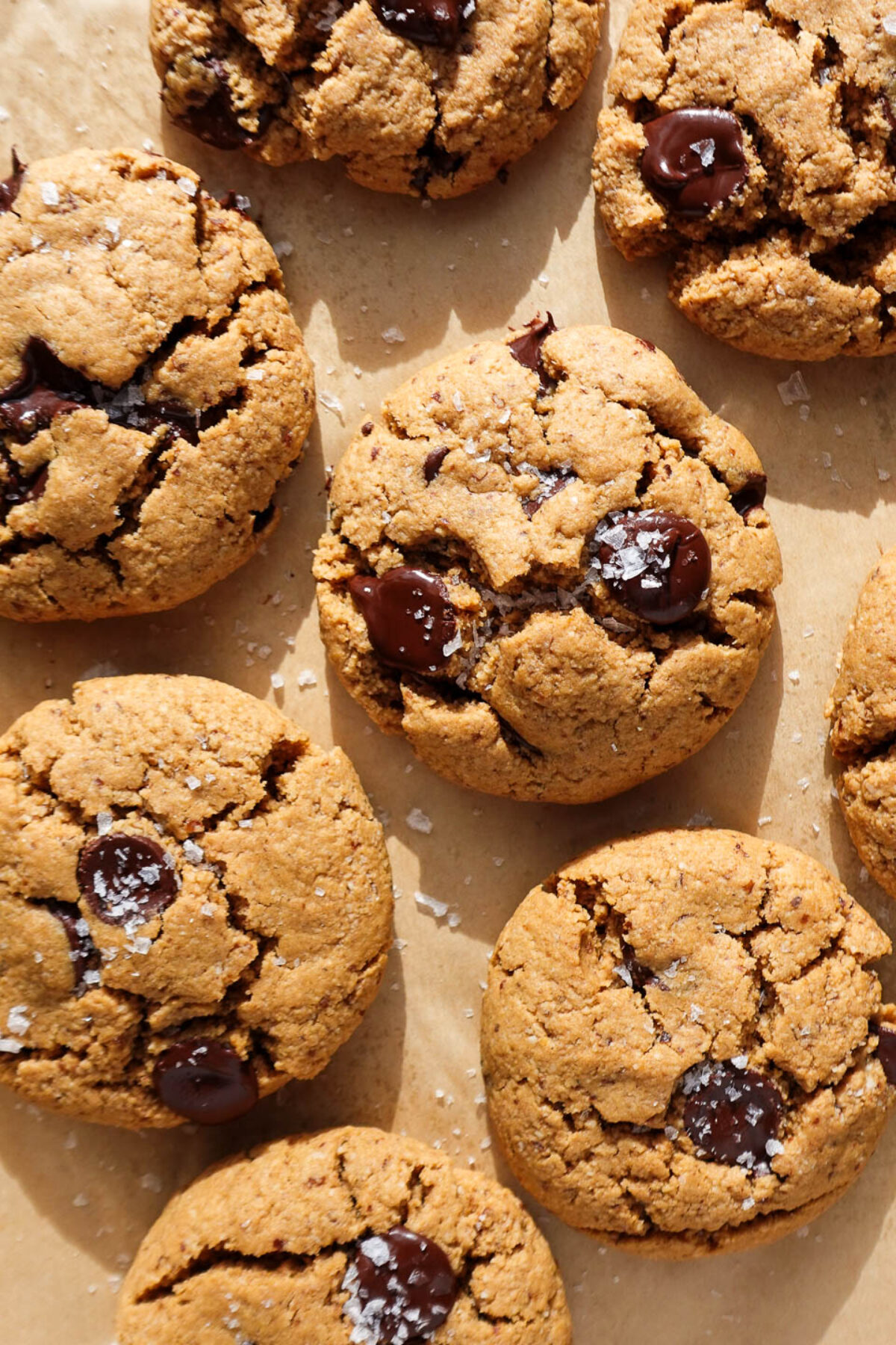 gluten-free and vegan chocolate chip cookies freshly baked on a baking sheet and sprinkled with flaky sea salt