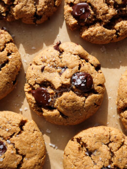 gluten-free and vegan chocolate chip cookies freshly baked on a baking sheet and sprinkled with flaky sea salt
