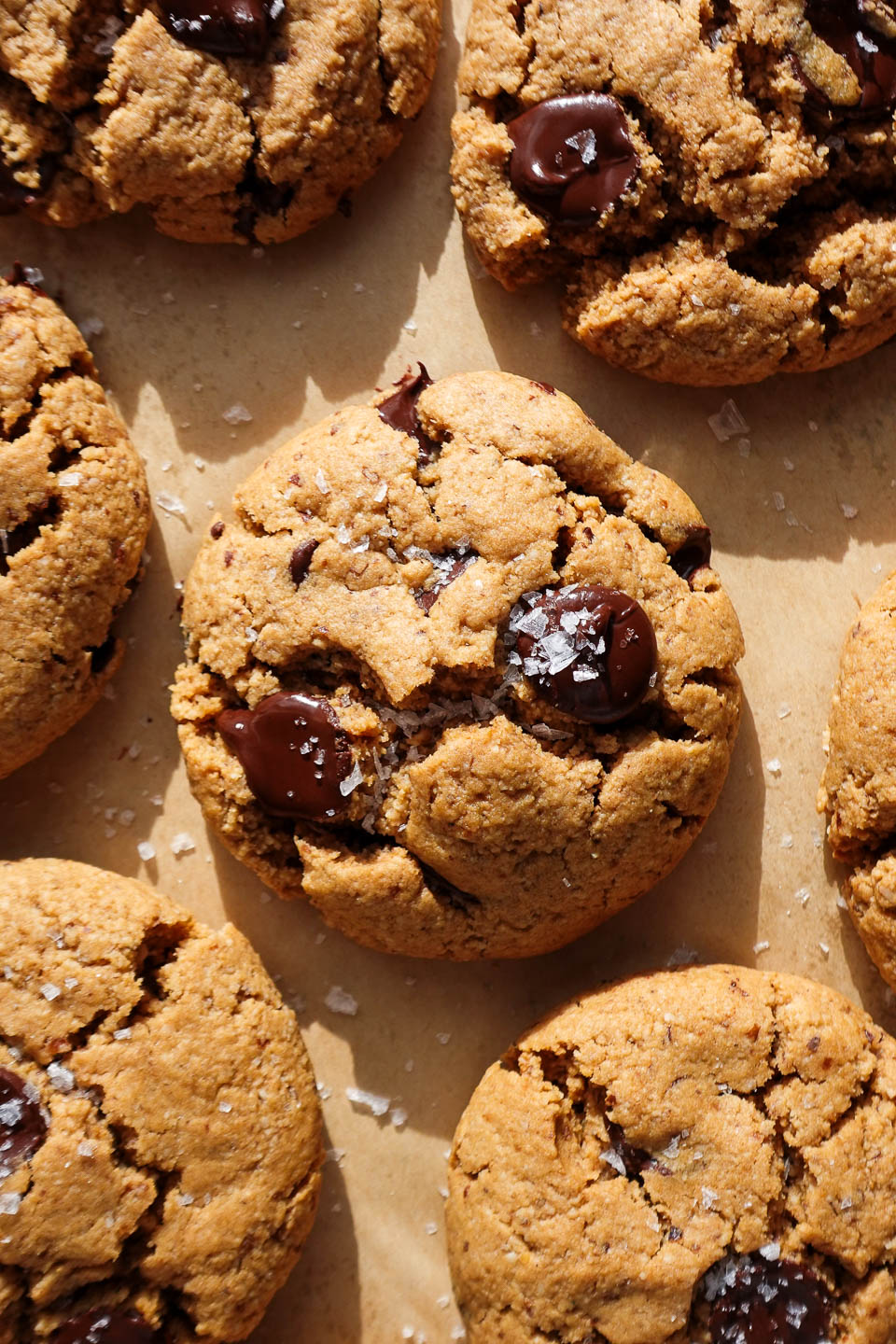 gluten-free and vegan chocolate chip cookies freshly baked on a baking sheet and sprinkled with flaky sea salt