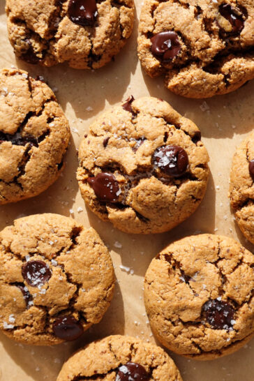 gluten-free and vegan chocolate chip cookies freshly baked on a baking sheet and sprinkled with flaky sea salt