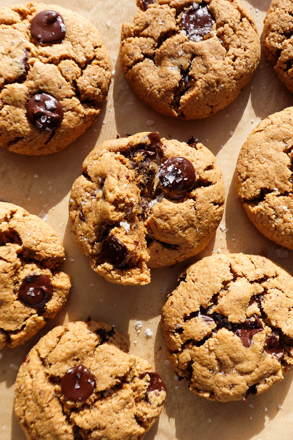 gluten-free and vegan chocolate chip cookies freshly baked on a baking sheet and sprinkled with flaky sea salt