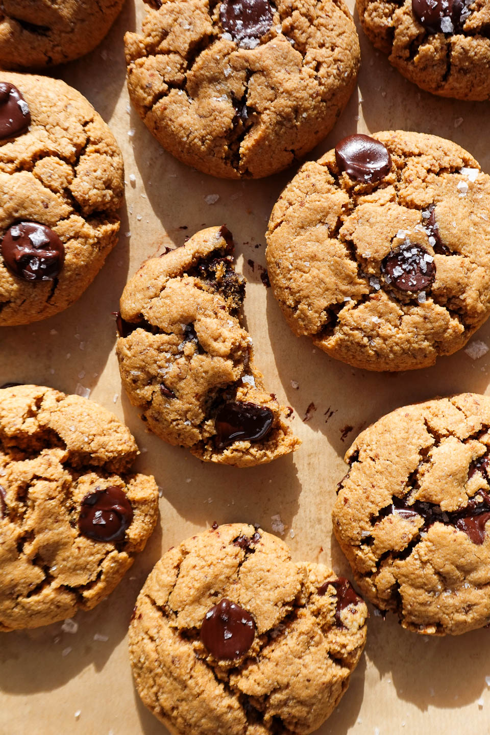 gluten-free and vegan chocolate chip cookies freshly baked on a baking sheet and sprinkled with flaky sea salt