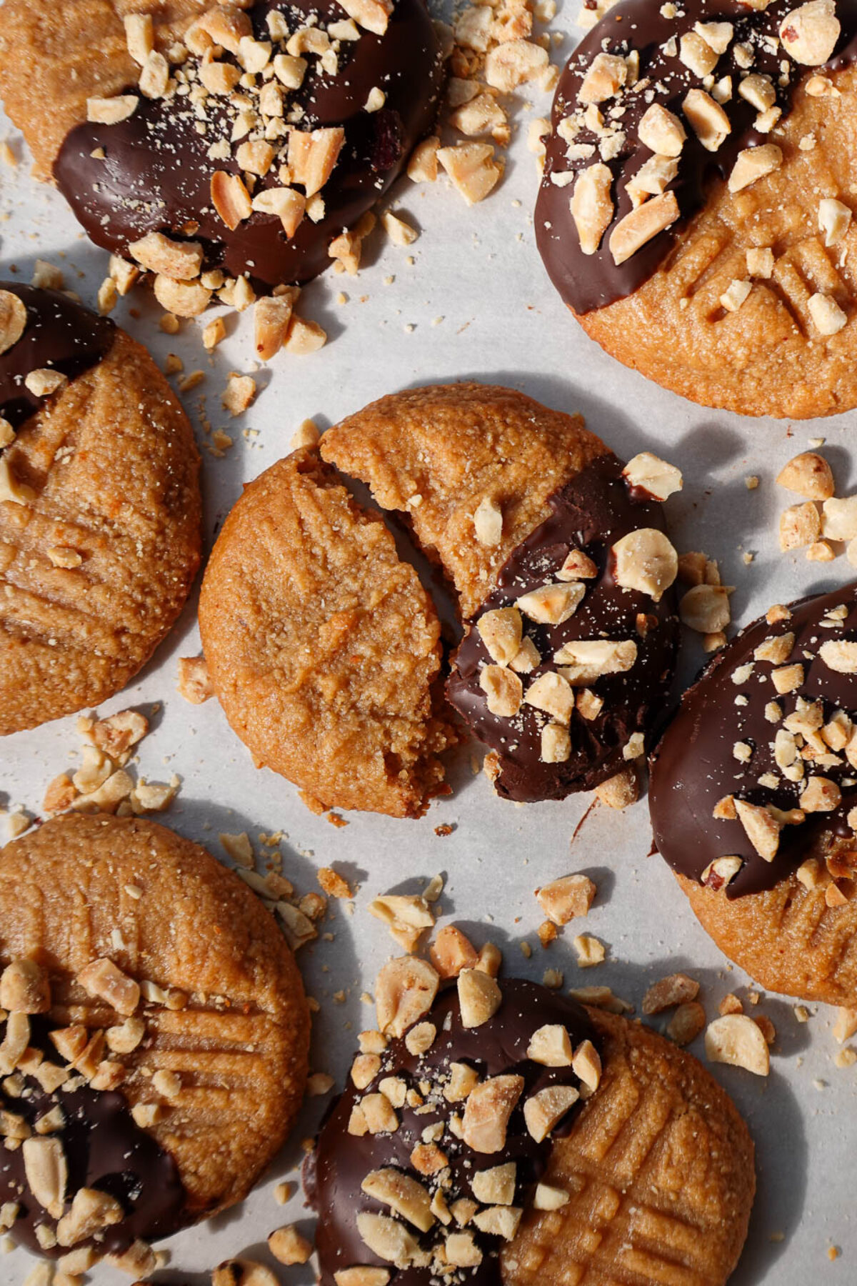 Overhead view of 3 ingredient peanut butter cookies half dipped in chocolate and sprinkled with chopped peanuts