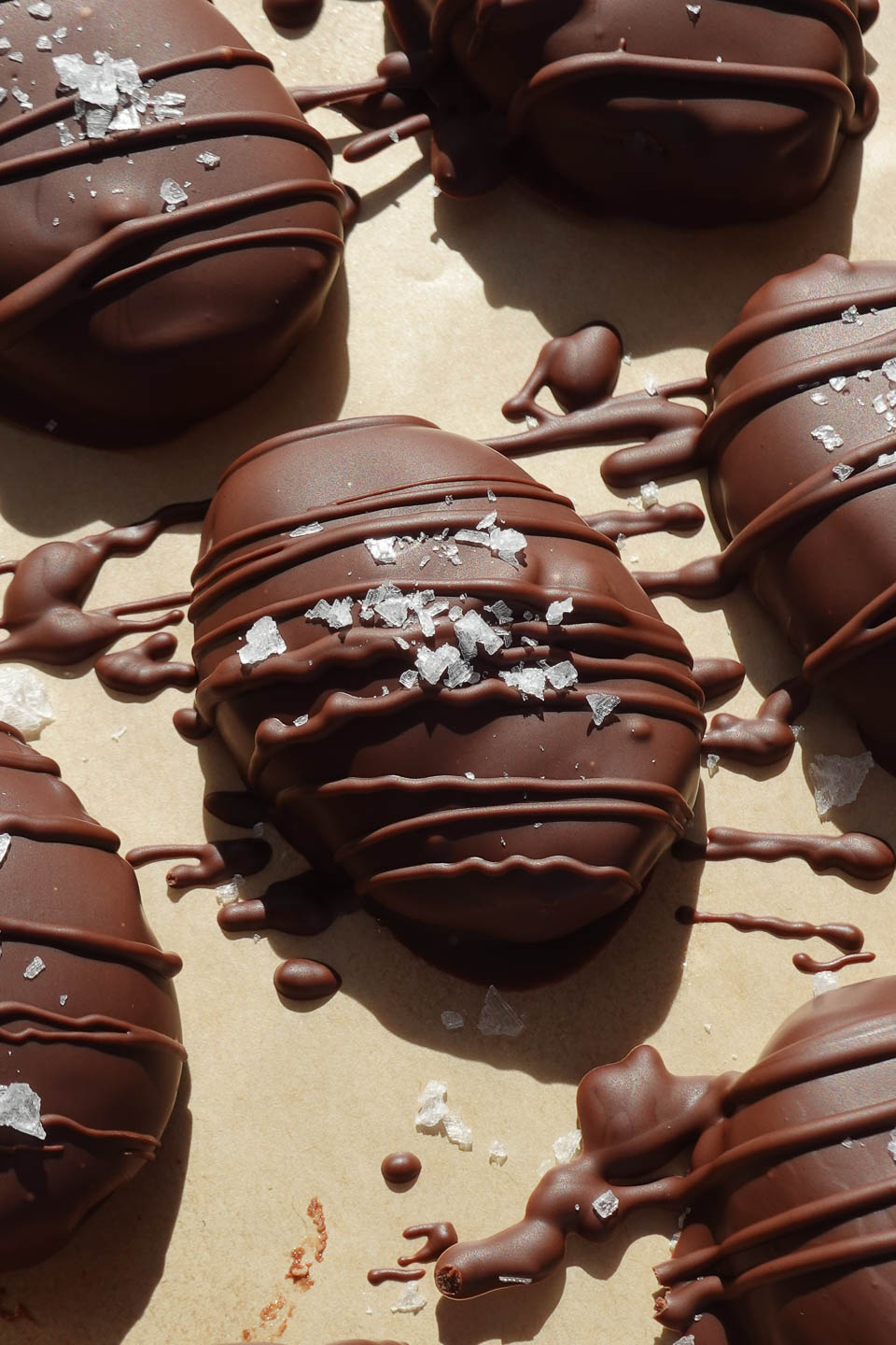 Chocolate coated peanut butter eggs on a baking sheet as the chocolate sets