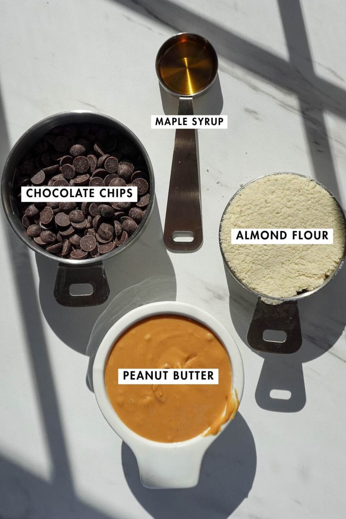 Ingredients needed to make vegan peanut butter eggs including peanut butter, almond flour, maple syrup, and chocolate chips
