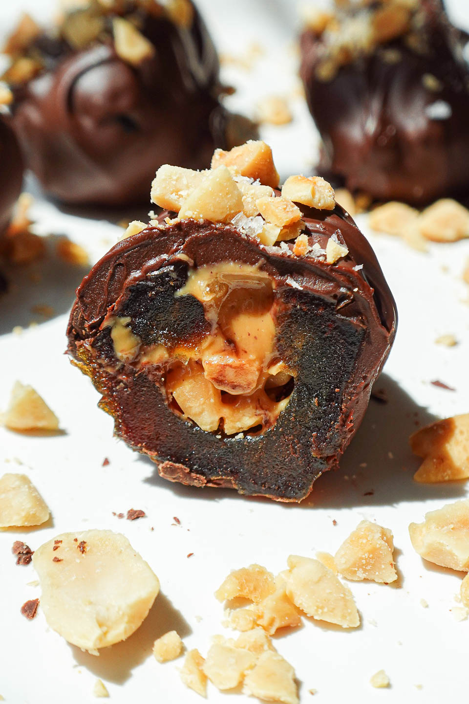 Close-up of gooey Snickers Stuffed Date, showing the peanut butter and chopped peanut filling inside.