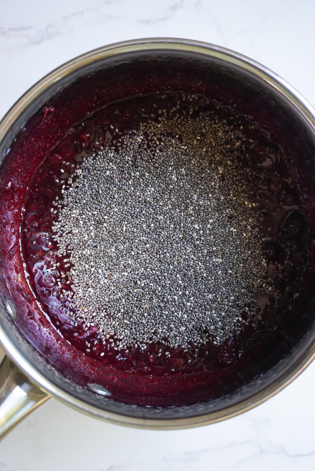 chia seeds and fruit in a pot to make chia jam