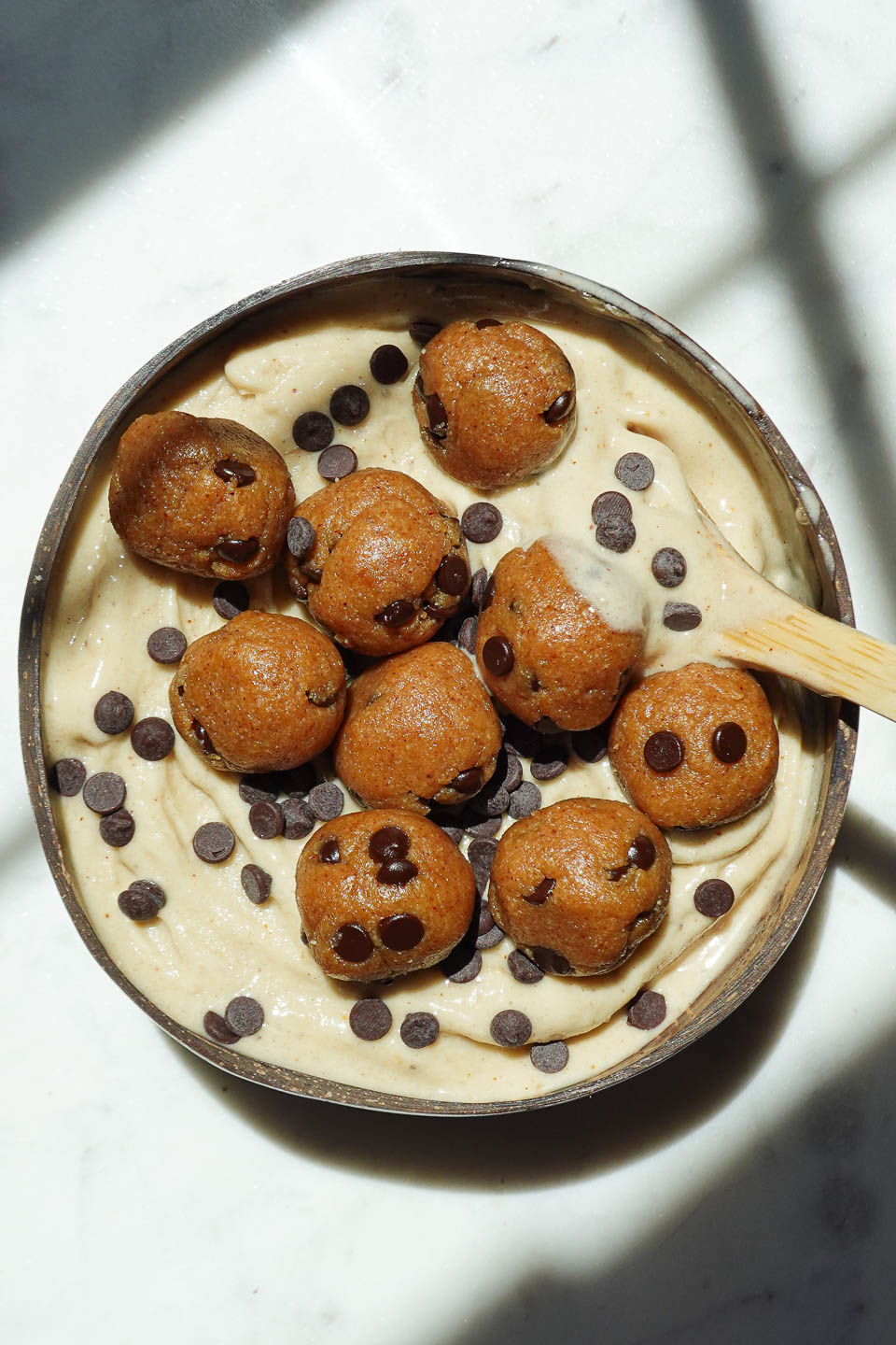 Vegan cookie dough nice cream served in a bowl with chocolate chips and cookie dough pieces on top
