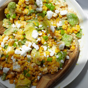 Vegan Mexican street corn salad with avocado, vegan feta, jalapeños, and lime.
