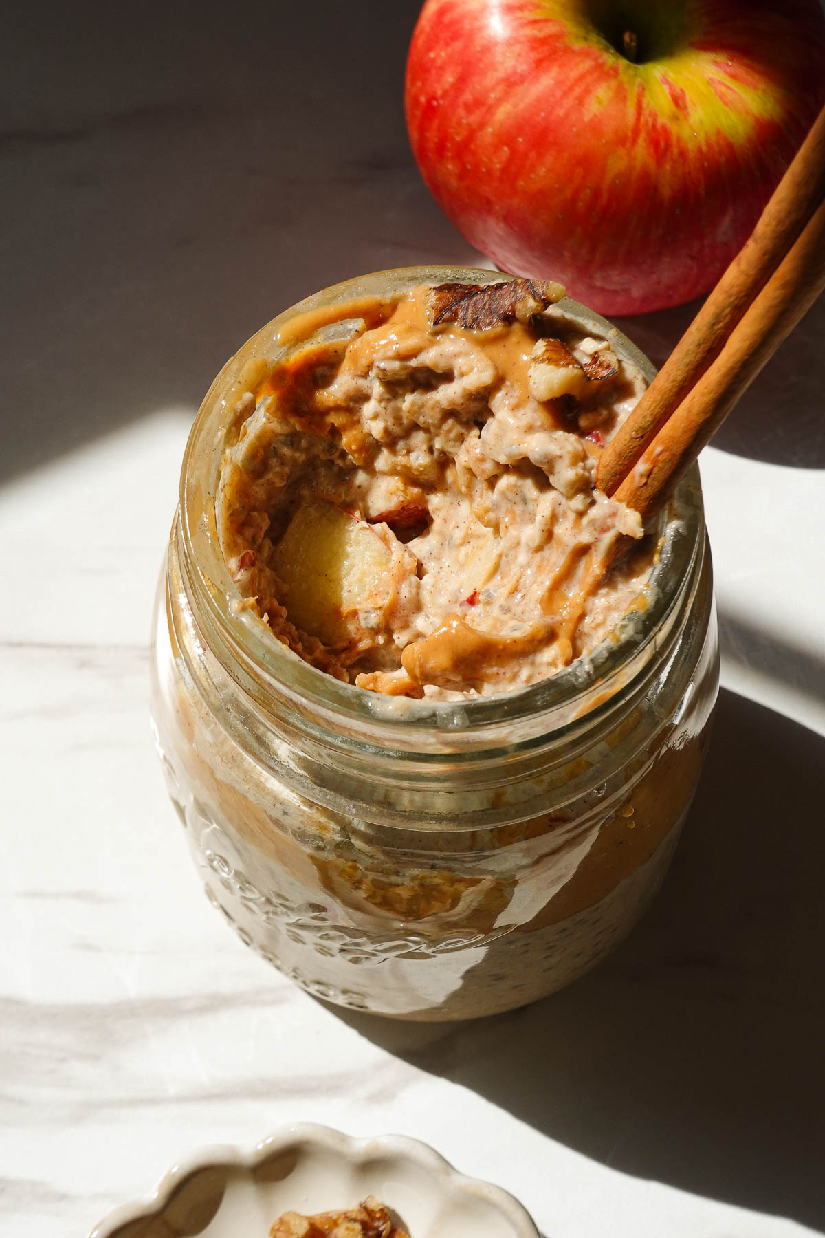 Spoonful of creamy apple cinnamon overnight oats showing the soft, pudding-like texture.