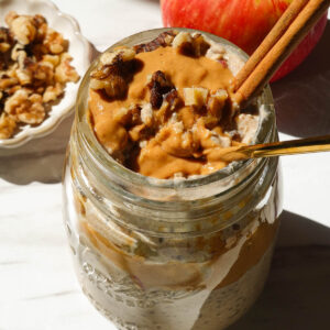 Creamy apple cinnamon overnight oats with shredded apple, cinnamon, and a drizzle of almond butter.