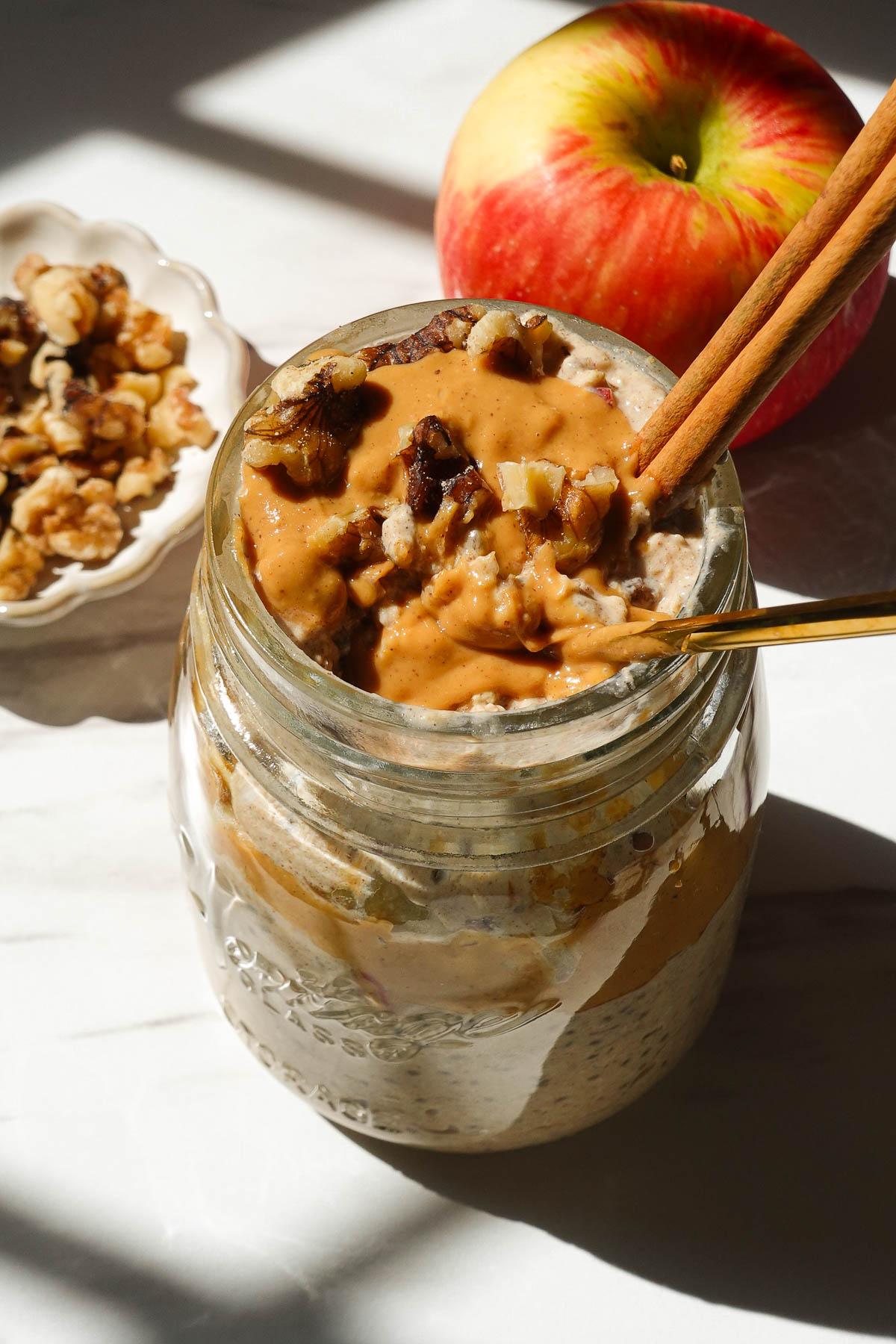 Creamy apple cinnamon overnight oats with shredded apple, cinnamon, and a drizzle of almond butter.