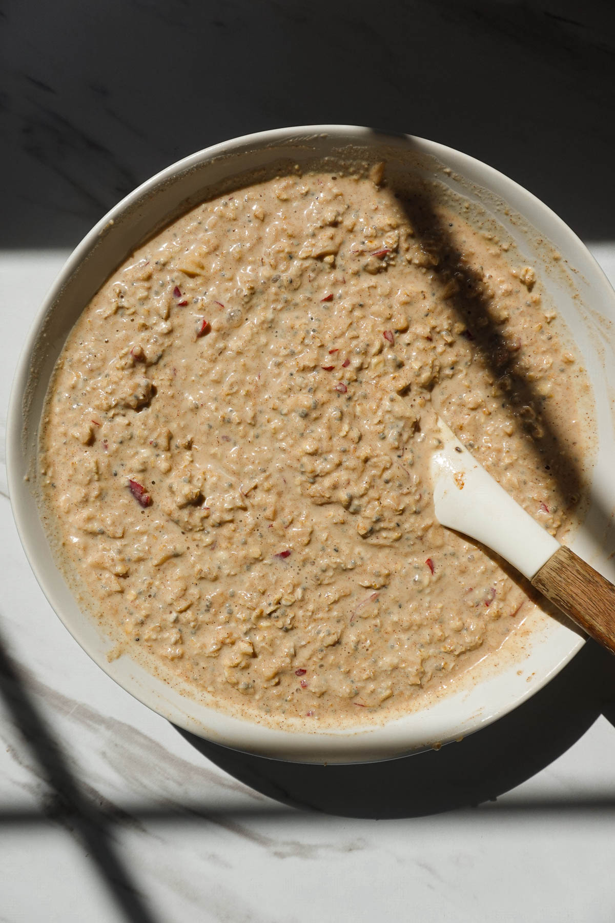Apple cinnamon overnight oats mixture in a bowl before refrigerating.