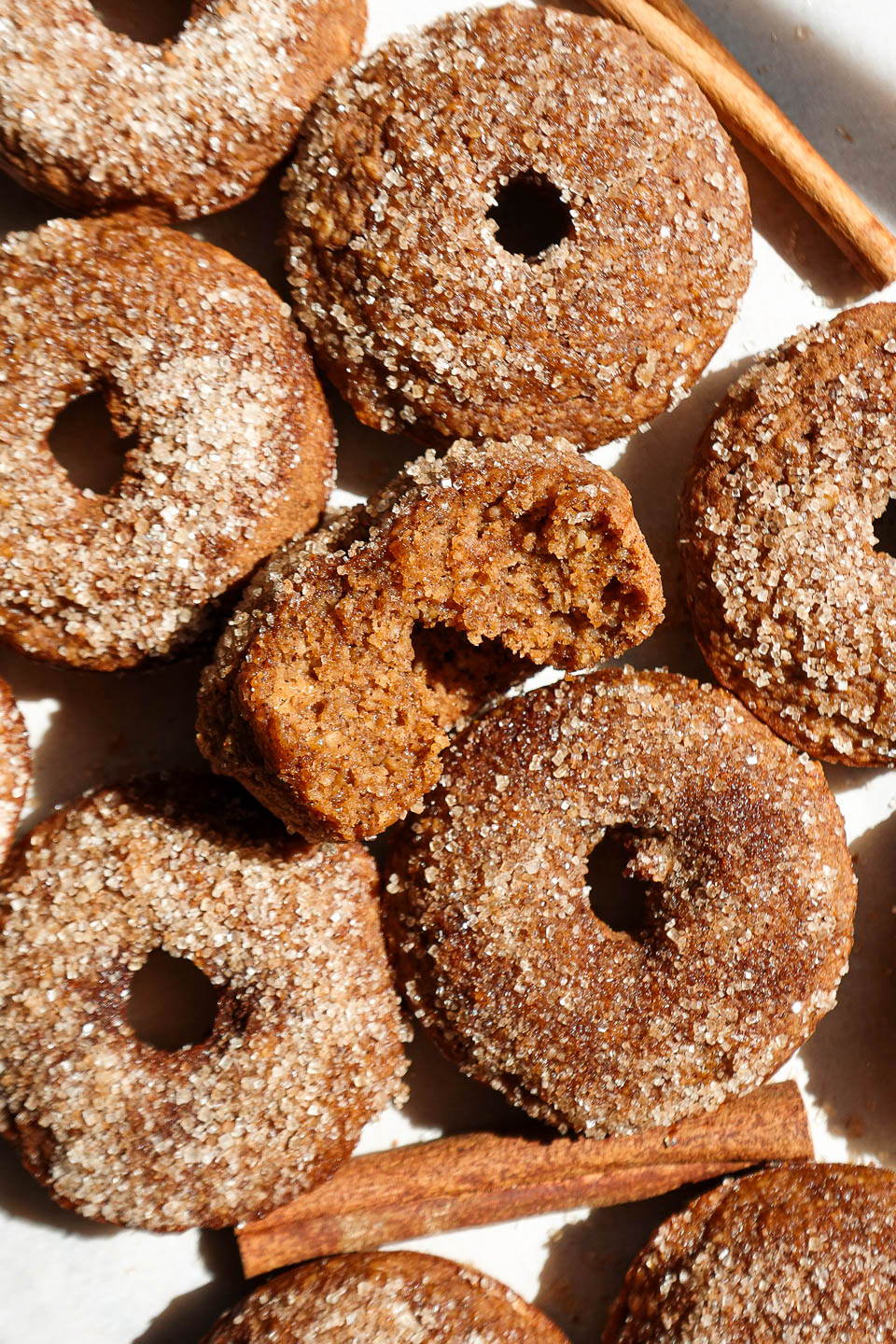 Baked apple cider donuts coated in cinnamon sugar on a plate