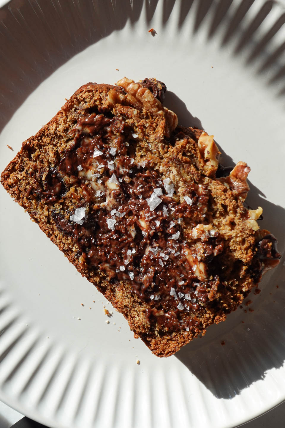 slice of freshly baked banana bread with melty chocolate chips and flaky sea salt