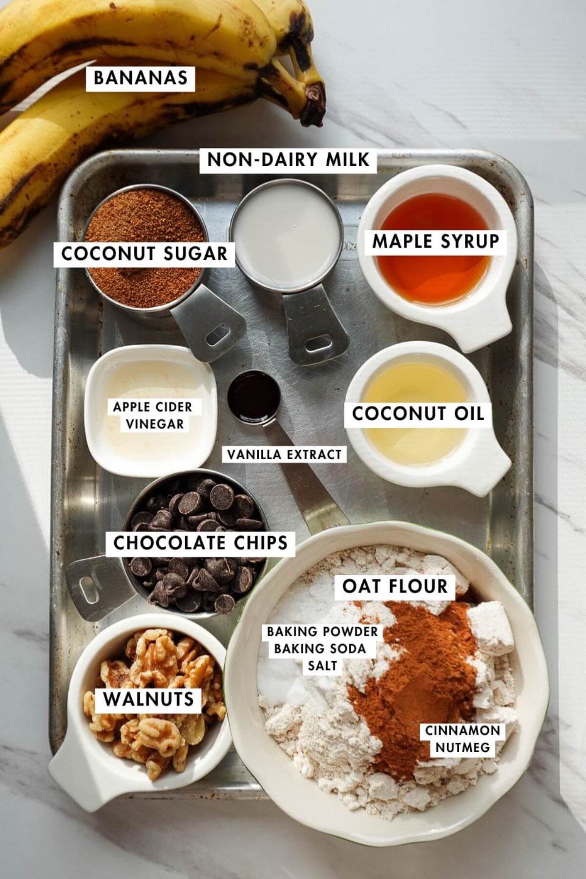 Ingredients needed to make healthy banana bread including bananas, oat flour, and coconut sugar.