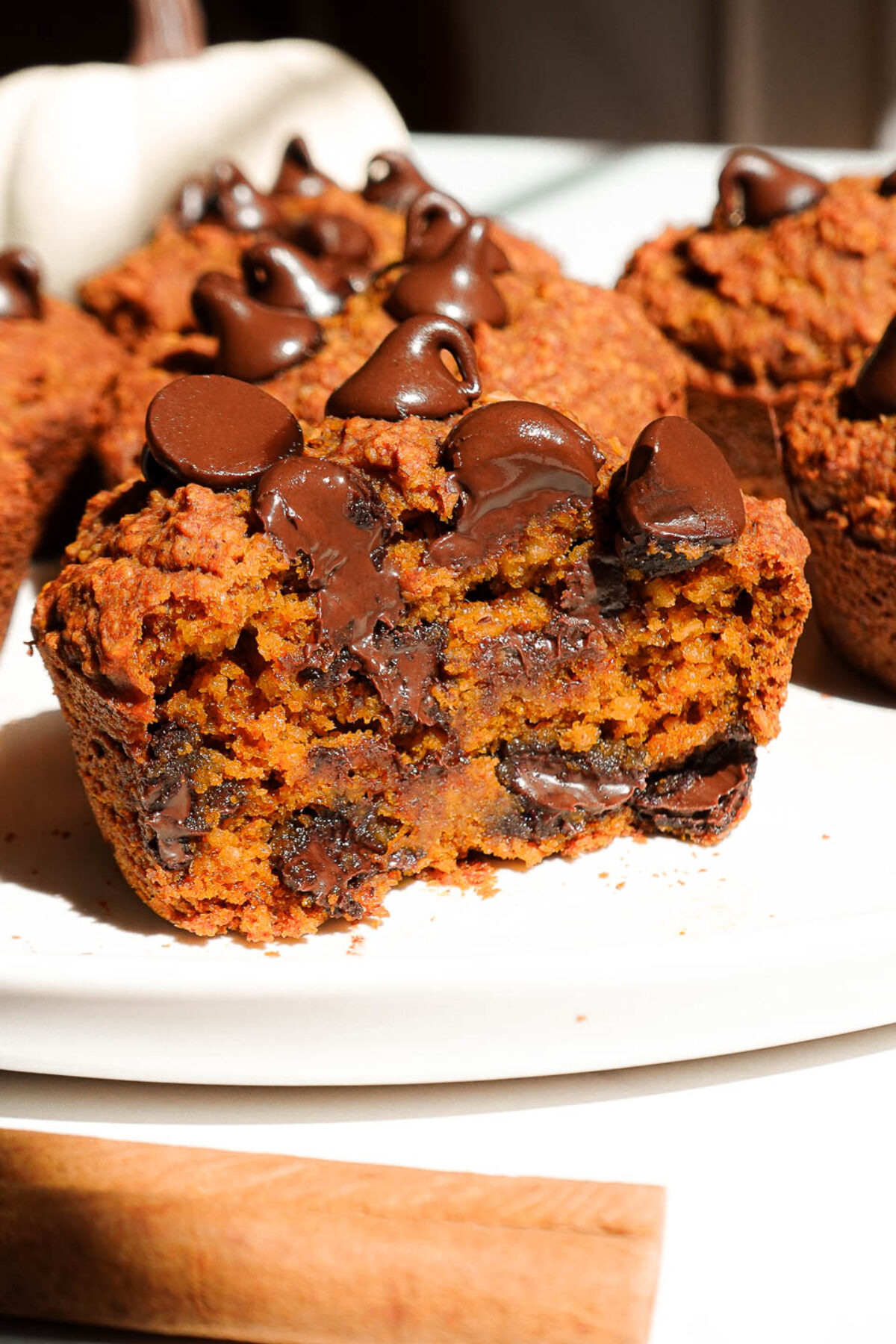 moist and fluffy pumpkin muffin cut in half to show soft crumb and melty chocolate chips